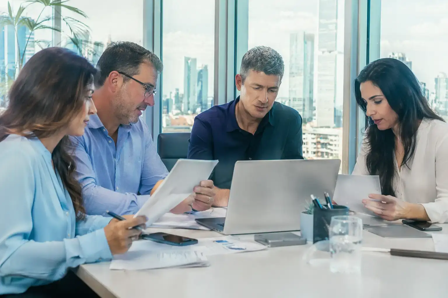 צוות במשרד מודרני בוחן תיקים ונותן שירות בסביבת עבודה מקצועית ונעימה